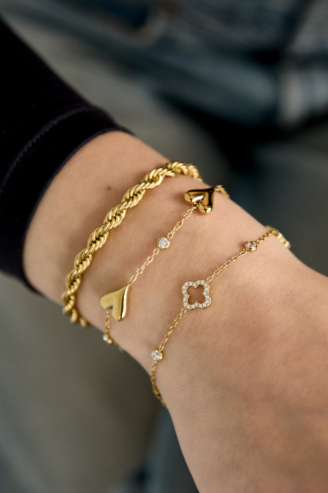 Armband mit durchbrochenem Muster und eingelegten Kleeblättern und Steinen